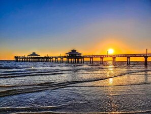 A pier extending into the sea with a sunset in the background. - Gulf Gateway-Pool/Dock/Grill/Fun (Fort Myers)