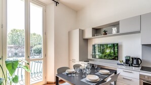 A modern kitchen with a dining area, large windows, and a view of greenery. - AwesHome Luxury Apartment (Pisa)