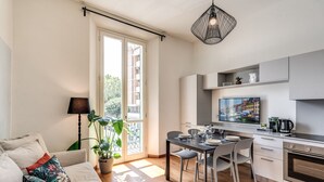 A modern apartment with a dining area, kitchenette, and a sofa with colorful cushions. - AwesHome Luxury Apartment (Pisa)