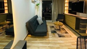 Un salon moderne avec un canapé, un téléviseur et un coin repas.
