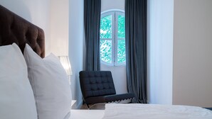 A hotel room with a bed, a chair, a window with curtains, and a lamp. - Vienna Residence, Frankfurt - Schweizer Platz #6067 (Frankfurt)