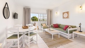 Un salon moderne comprenant un coin repas, un canapé et un téléviseur.