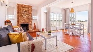 Una sala de estar con chimenea, un sofá, una mesa de centro y un comedor con sillas y una mesa.