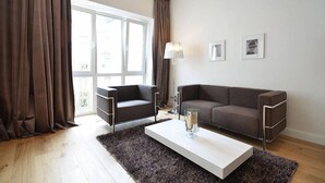Un salon moderne avec un canapé, une table basse et une lampe.