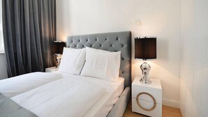 A neatly made bed with white linens, a tufted headboard, and two bedside tables with lamps. - Vienna Residence, Frankfurt - Schweizer Platz #6078 (Frankfurt)