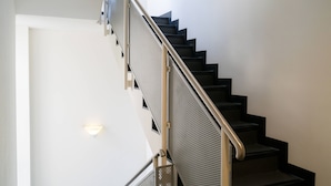 A modern staircase with a metal railing and a white door at the bottom. - Vienna Residence, Frankfurt - Schweizer Platz #6084 (Frankfurt)