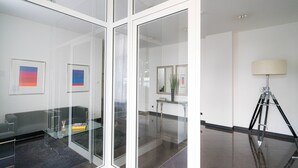 A modern office space with a glass partition, a desk, a lamp, and framed artwork on the wall. - Vienna Residence, Frankfurt - Schweizer Platz #6084 (Frankfurt)