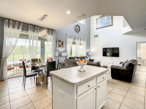 Relax in this stylish living area with a central island, dining table, and comfortable sofa.