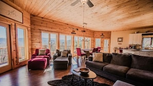 Un intérieur spacieux en bois, comprenant un coin repas, un canapé et une table basse.