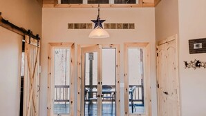 Un intérieur en bois, avec un plafond en bois, un luminaire suspendu en forme d’étoile et un tapis à motifs animaliers.