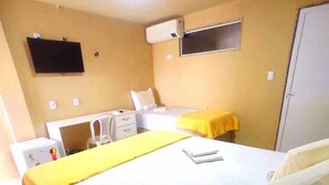 A hotel room with a bed, a desk, a chair, a TV, and a wardrobe. - Amazônia Praia Hotel (Tibau)