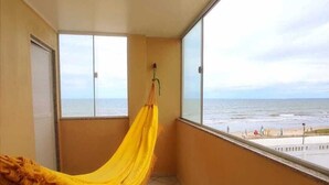 A balcony with a yellow hammock, a view of the sea, and tiled flooring. - Amazônia Praia Hotel (Tibau)