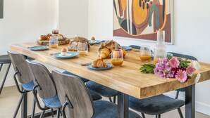 Et morgenbord dækket med croissanter, brød, frugt og juvelglas.