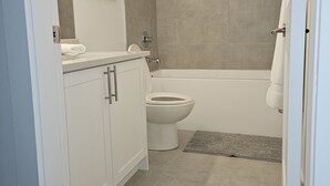 Een badkamer met toilet, bad en wastafel.