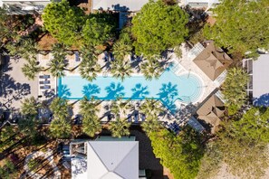 An aerial view of a resort with a central swimming pool surrounded by palm trees and lounge areas. - Lion on the Beach - Community Pool, Bikes + Golf Cart, Great 30A Locale! (Seagrove Beach)