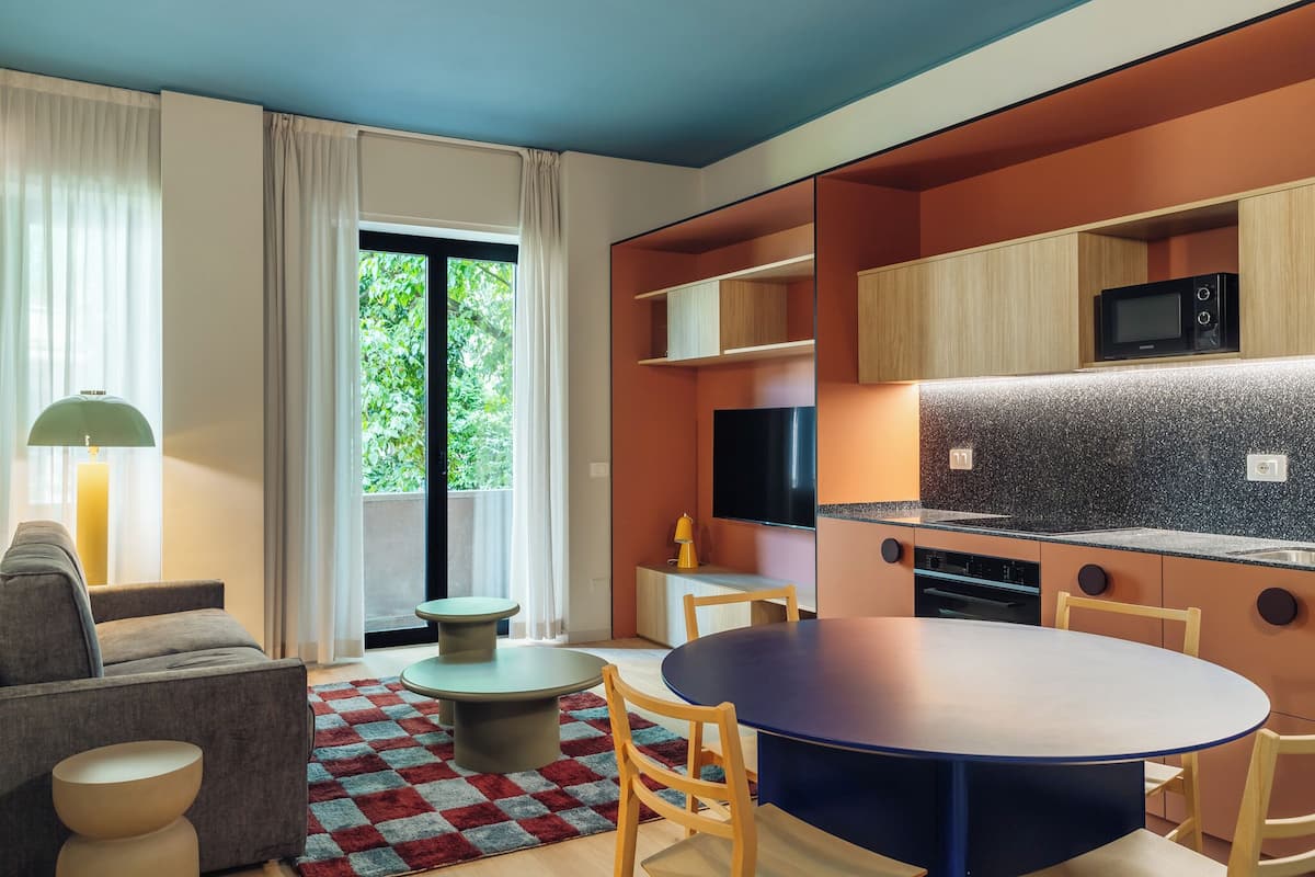 Une cuisine moderne équipée d’un four à micro-ondes, de placards et d’un coin repas avec une table et des chaises.
