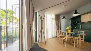 Une cuisine moderne avec un coin repas, de grandes fenêtres et un balcon.