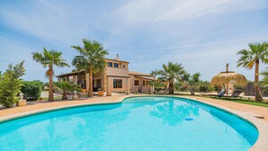 Piscina com uma casa ao fundo.