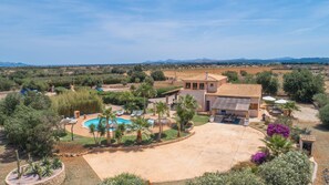 Relax in a Mediterranean-style retreat surrounded by lush landscaping and palm trees, with a swimming pool and covered patio area.
