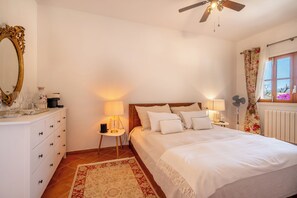 Relax in a classic bedroom with a large bed, wooden headboard, and ornate mirror.