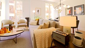 A modern living room with a sofa, armchairs, a coffee table, and a vintage radio. - Justicia Royal by Madflats Collection (Madrid)