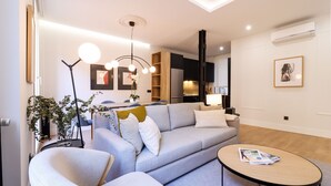 A modern living room with a sofa, armchairs, a coffee table, and a floor lamp. - Justicia Royal by Madflats Collection (Madrid)
