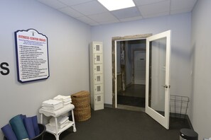 A fitness center with a sign listing rules, a storage cabinet, a door, and a small table with folded towels. - Huge 4BDR Cottage for 12 with game room in fabulous Stormy Point Village.  (Branson)