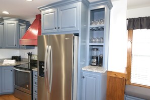 Une cuisine équipée d’un réfrigérateur en acier inoxydable, d’une cuisinière et d’une machine à café.