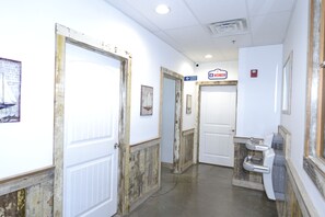 A hallway with doors, a sign for the women's restroom, and a fitness center sign.