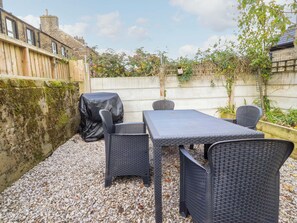 A patio area with a table and chairs, covered by a black tablecloth. - 10 Haw Grove (Skipton)
