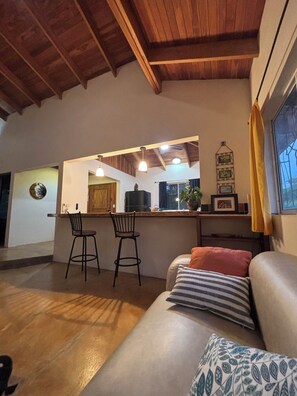 Una sala de estar acogedora con un sofá, un comedor con dos sillas y una encimera de cocina.