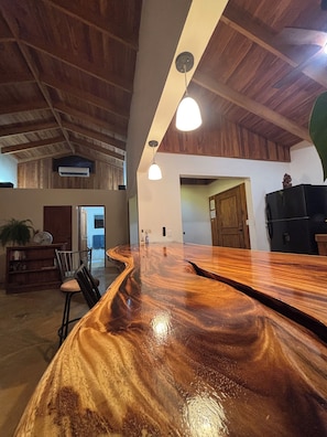 A spacious kitchen with a wooden countertop and pendant lighting.