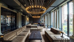 A modern lounge area with a large sectional sofa, a coffee table, and a chandelier. - New Studio Apartment - Gym, roof terrace, Cinema (London)