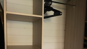Een inloopkast met meerdere planken en een kledingroede.