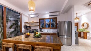 A modern kitchen with a large island, stainless steel appliances, and a view of the outdoors. - Entire villa for 8 people (El Paredon)