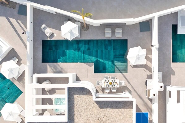 Un área de piscina en la azotea con sillones de descanso, una mesa con una bebida y un jacuzzi.