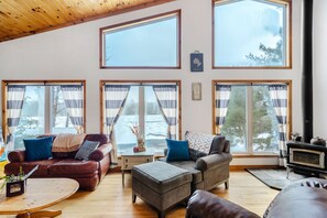 Una sala de estar acogedora con chimenea, ventanas amplias y un espacio de descanso cómodo.