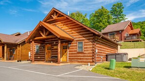 Une cabane en rondins avec une véranda, un espace extérieur couvert avec des sièges et une petite fenêtre.
