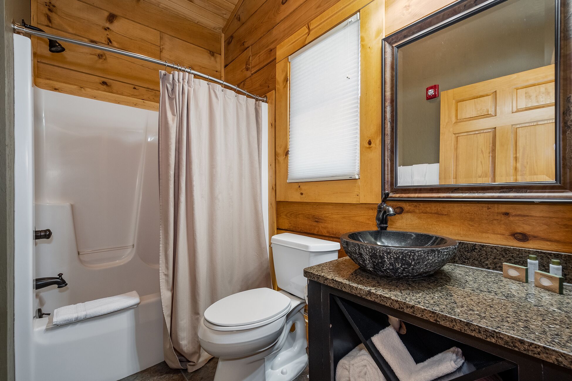 A bathroom with a bathtub, toilet, and sink.