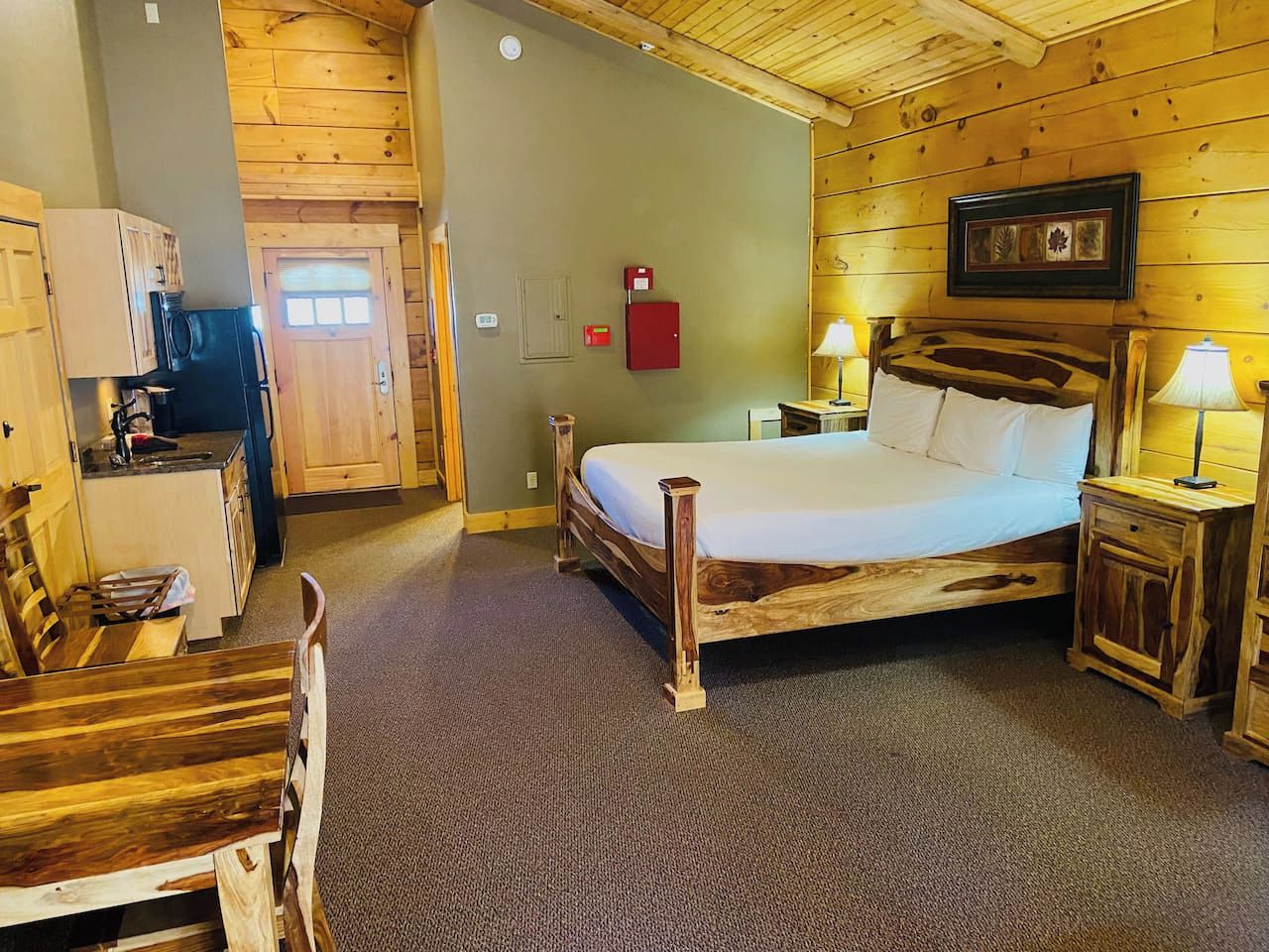 A wooden room with a bed, a desk, and a chair.