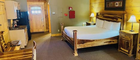 A wooden room with a bed, a desk, and a chair.