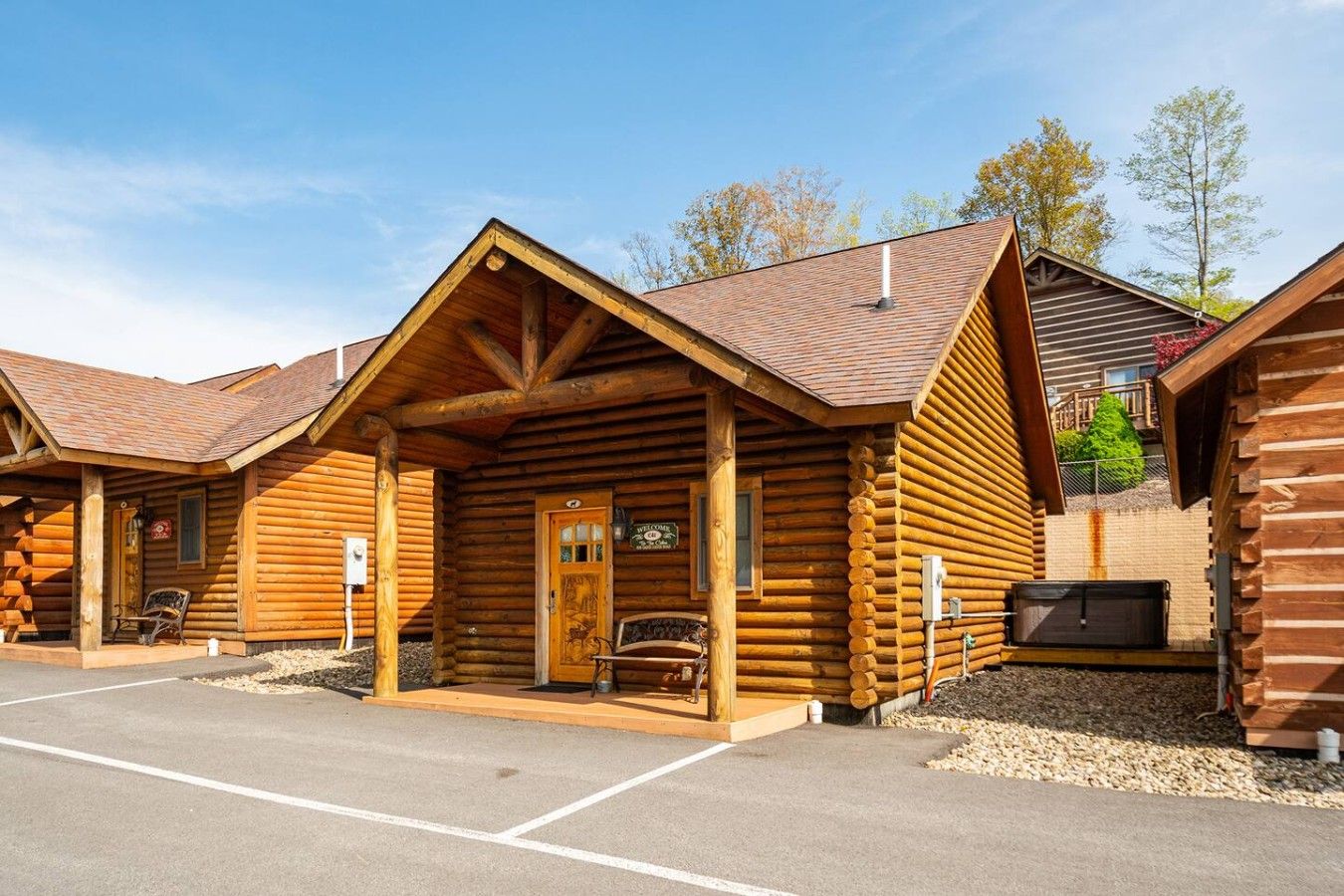 Un bâtiment de style chalet en bois, doté d’une entrée accueillante, d’un porche couvert et d’un espace de stationnement à l’avant.