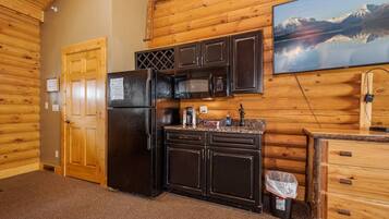 A compact kitchen with a refrigerator, microwave, and wooden cabinets.