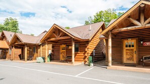Une rangée de chalets en rondins avec un espace de stationnement couvert à l’avant.