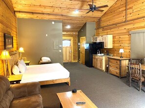 A room with a bed, a desk, a chair, a lamp, and a ceiling fan.