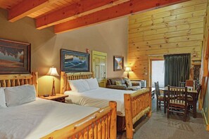 A room with two wooden beds, a wooden table, and a couch. - C46R - 3 Queen Beds, Duplex (McHenry)