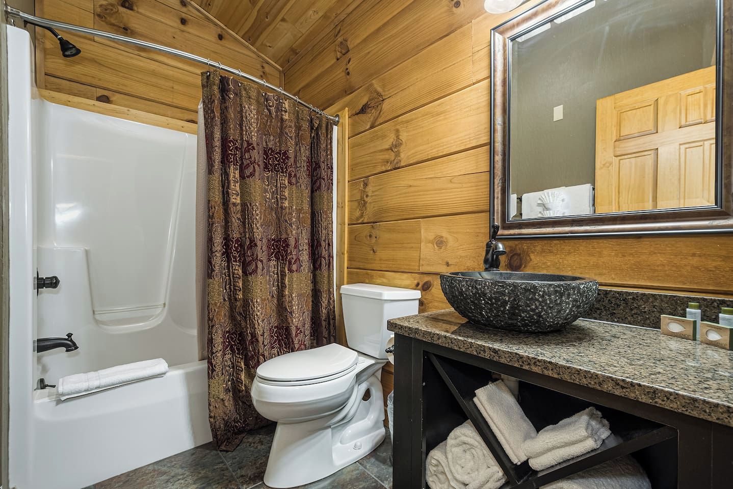 Un baño con bañera, inodoro y lavabo de gran tamaño.