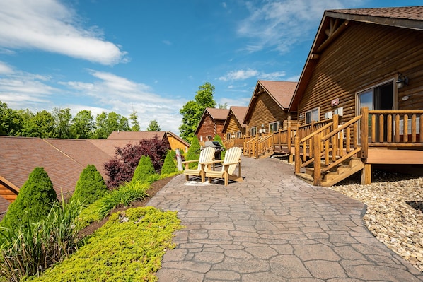 A row of log cabins with wooden decks and outdoor seating.