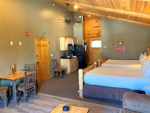 A room with a bed, a desk, a chair, a kitchenette, and a ceiling fan. - C49L - 2 Queen Beds, Duplex (McHenry)
