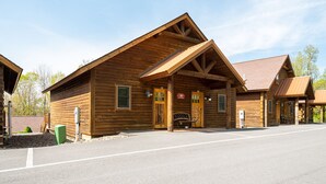 A log cabin with a welcoming entrance, a porch, and a chimney.